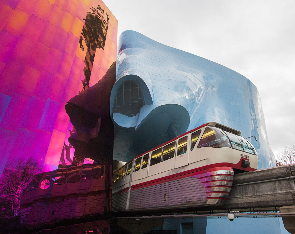 Nick Benson Mono Rail Going Through Neon Glass Buildings