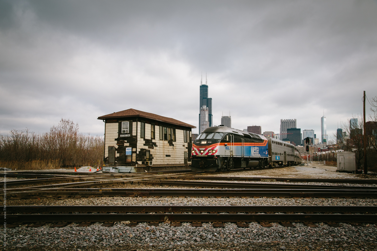 An inbound Metra train for LaSalle Street Station crosses the diamond protected by the 16th St. Tower outside downtown Chicago. The tower stands over the crossing of Metra's Rock Island District over the St. Charles Air Line and former Illinois Central line west now Canadian National. The first tower was built here in 1901.