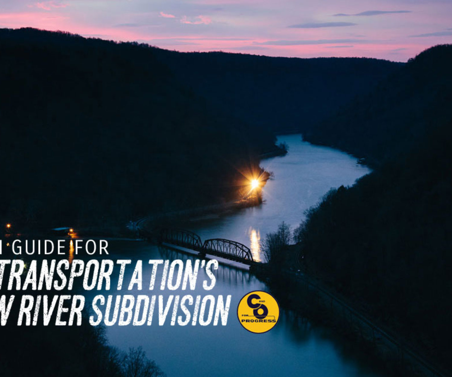The yellow glow of another CSX coal train slowly glides along the New River in the dawn darkness as the sun slowly begins to rise and paint the sky in shades of pinks and violets.